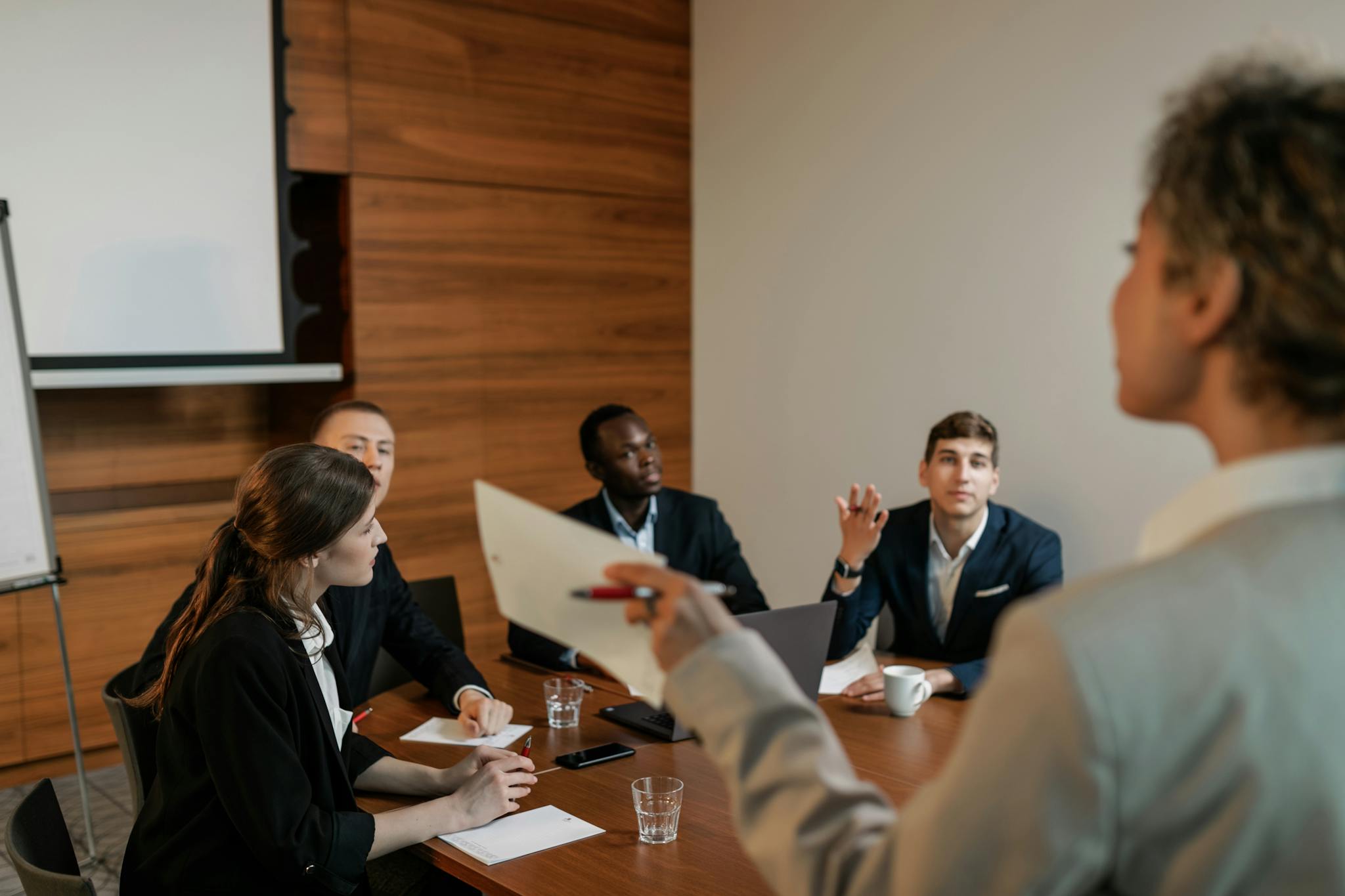Professional business team engaged in a discussion in a modern conference room setting.